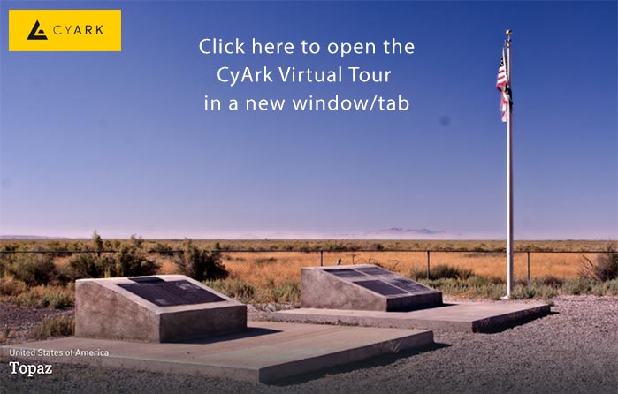 Two monuments and a flag in a desert environment.